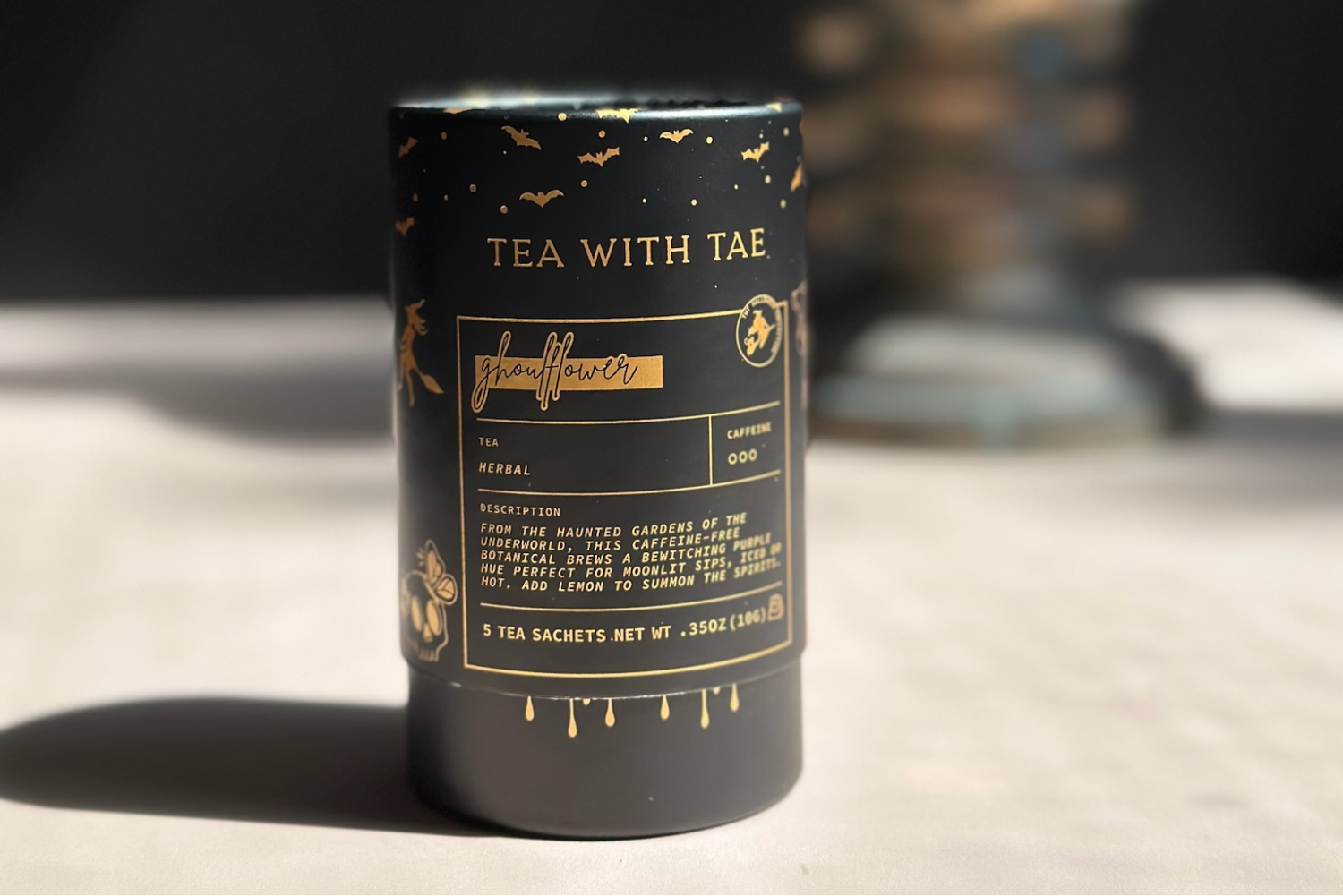 Black tea canister with gold text on a wooden surface